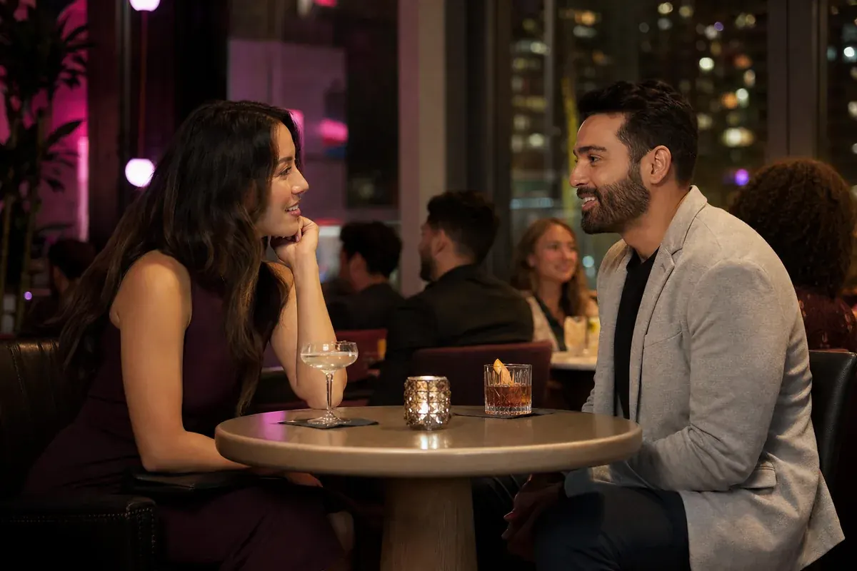 Two Canadian adults enjoying a relaxed first meetup in a busy public cocktail lounge